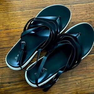 pair of black slip on flip flops with adjustable strap